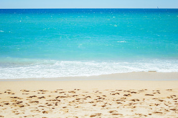 Footprints in the sand against the background of the sea