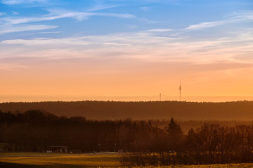 Beautiful rural sunset landscape with the television tower of Nuremberg in the background. Seen in Bavaria, Germany in January from Tauchersreuth.