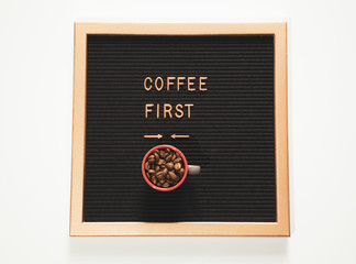 coffee first words on modern board at white background, top view. Overhead, flat lay, from above. Red coffee mug with fresh coffee beans