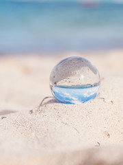 Fototapeta na wymiar Close-up on Mini Glass Ball on the Beach 