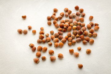 Whole hazelnuts lying on a white table
