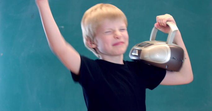 boy blond enthusiastically listens to music on a small tape recorder