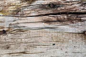 Old Dark rough wood floor or surface with splinters and knots. Background with flooring or boards with wood grain. Old aged timber in a barn or old house. 