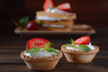 Belgian waffles with strawberries, whipped cream and mint leaves. Tasty dessert concept