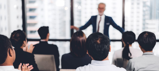 Businessman standing in front of group of people in consulting meeting conference seminar at hall...