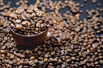 Coffee cup and roasted coffee beans, close up. An invigorating drink.