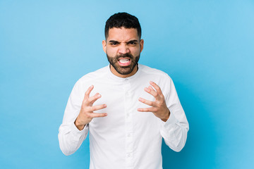 Naklejka premium Young latin man against a blue background isolated upset screaming with tense hands.
