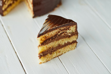Dark chocolate vegan cake with candies and nuts on wooden background