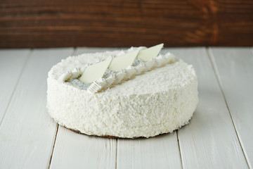 Birthday cake with white chocolate, butter cream and poppy seed biscuit on wooden background