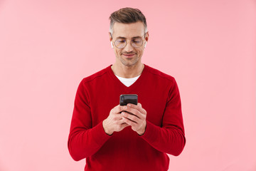 Portrait of handsome man wearing eyeglasses and earbuds holding smartphone