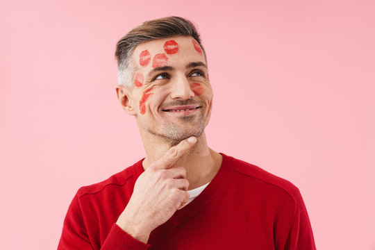 Portrait of handsome man with kiss marks on his face on valentines day