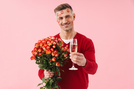Portrait of man with kiss marks holding flowers and champagne glass