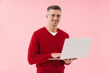 Portrait of handsome man wearing eyeglasses holding laptop computer
