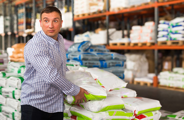Adult man buying compost soil for gardening