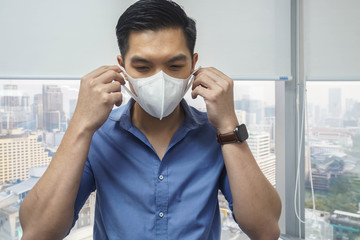 Editorial content -businessman wear white N95 mask before going outdoors to prevent pm 2.5 and...