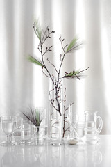 Scandinavian Easter interior decoration. Spring branch with plumets in glass vases in white room.