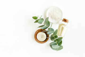Obraz na płótnie Canvas Bottle of eucalyptus essential oil, eucalyptus leaves on white background. Natural / Organic cosmetics products. Flat lay, top view.