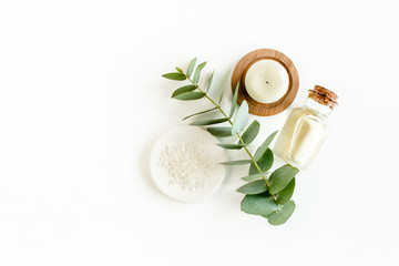 Bottle of eucalyptus essential oil, eucalyptus leaves on white background. Natural / Organic cosmetics products. Flat lay, top view.