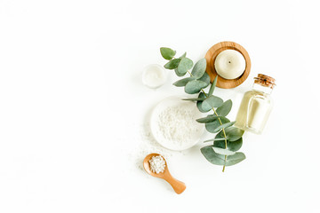 Bottle of eucalyptus essential oil, eucalyptus leaves on white background. Natural / Organic cosmetics products. Flat lay, top view.