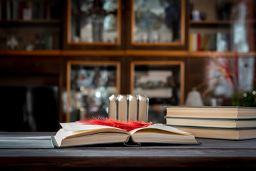 Open book with a bookmark on a wooden table.