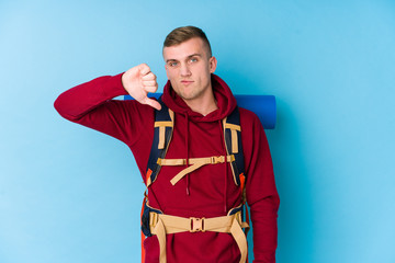 Young traveller caucasian man showing a dislike gesture, thumbs down. Disagreement concept.