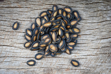 watermelon seeds on wood background / close up dried watermelon seed with salt for food or snack