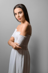 Beautiful fashionable young woman on grey background