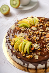 Homemade delicious sweet cake with fruits, chocolate, apple, kiwi on cup of coffee americano, white background. Organic dessert sugarless. Healthy eating.