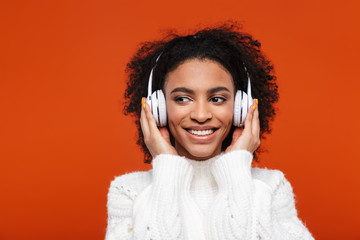 Cheerful young african woman listening to music