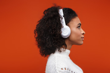 Cheerful young african woman listening to music