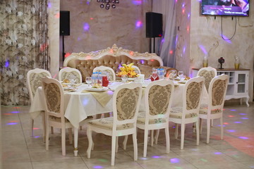 Festive table for 10 people. White tablecloth, white chairs