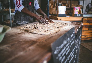 African man making bread with raw dough