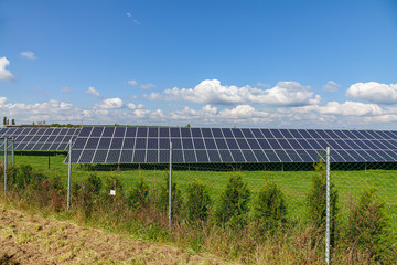  Solar energy panels on green field, blue sky