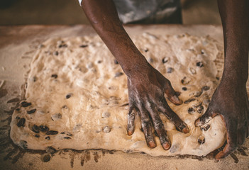 African man making bread with raw dough