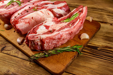 Raw pork ribs with spices, garlic and rosemary on wooden table