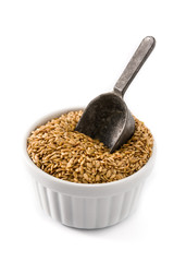 Golden flax seeds in white bowl isolated on white background