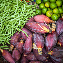 Fresh beans, banana flowers and lime for sale at asian market. Organic food background