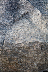 Stone background, rock wall backdrop with rough texture. Abstract, grungy and textured surface of stone material. Nature detail of rocks.