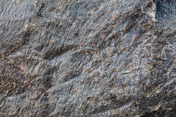 Stone background, rock wall backdrop with rough texture. Abstract, grungy and textured surface of stone material. Nature detail of rocks.