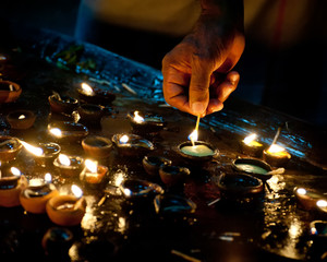 People burning oil lamps as religious ritual in Hindu temple. India