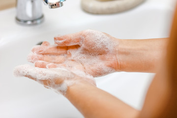 Fototapeta premium Hygiene concept. Washing hands with soap under the faucet with water