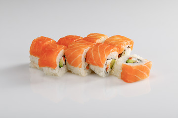 delicious Philadelphia sushi with avocado, creamy cheese, salmon and masago caviar on white background