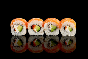 fresh delicious Philadelphia sushi with avocado, creamy cheese, salmon and masago caviar isolated on black