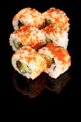 delicious California roll with avocado, salmon and masago caviar isolated on black