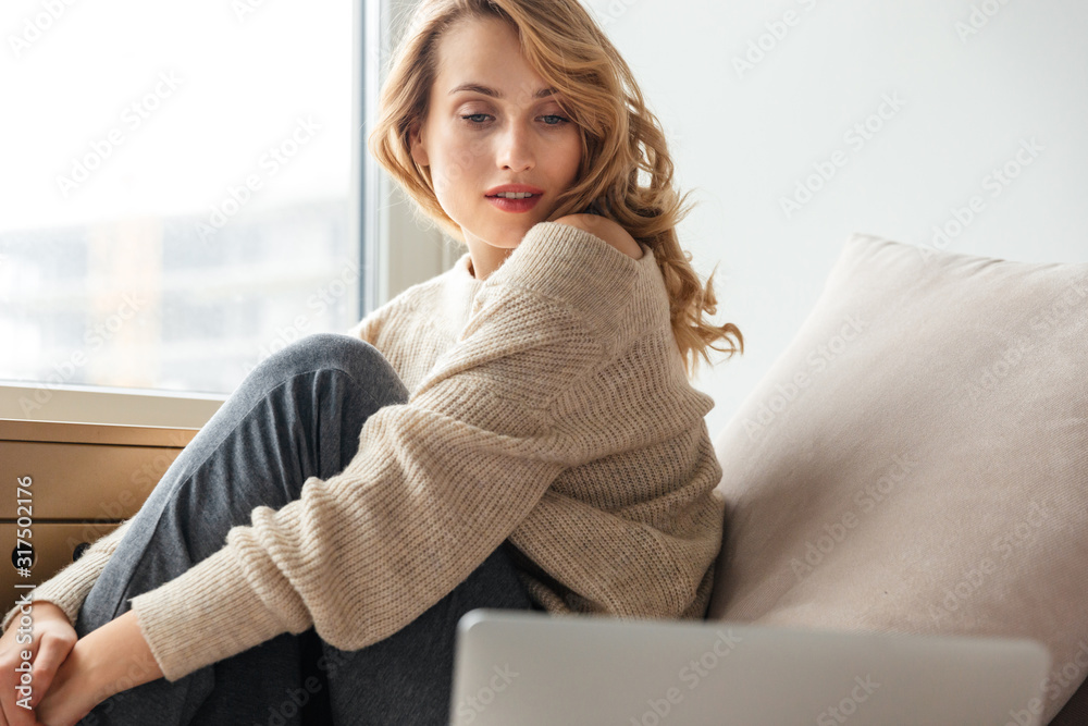 Poster Concentrated gorgeous young woman using laptop computer.