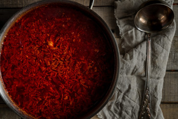 Freshly cooked traditional Russian anf Ukranian beetroot soup borcht in a pan on wooden rustic background