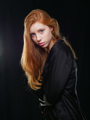 young girl with long red hair on a black background