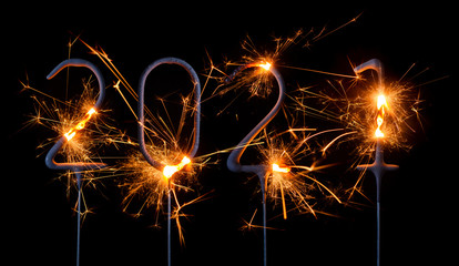 Happy New Year 2021. Digits of year 2021 made by burning sparklers isolated on black background.