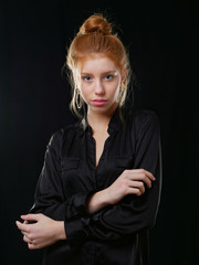 young girl with long red hair on a black background