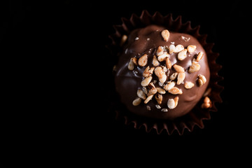 One Single Handmade Chocolate Praline Close Up View. Dark Background with Copy Space